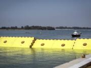 Moveable flood gates rise from the sea in the Venice lagoon, Italy, Friday, July 10, 2020. Venice has conducted a trial run an ambitious anti-flood system of 78 inflatable barriers in the hopes of protecting the lagoon city from devastating high tides. Premier Giuseppe Conte on Friday at a ceremony in Venice pressed a button that activated compressors to pump air into the bright yellow barriers, which then started rising from the sea to act a kind of a dike-on-demand.