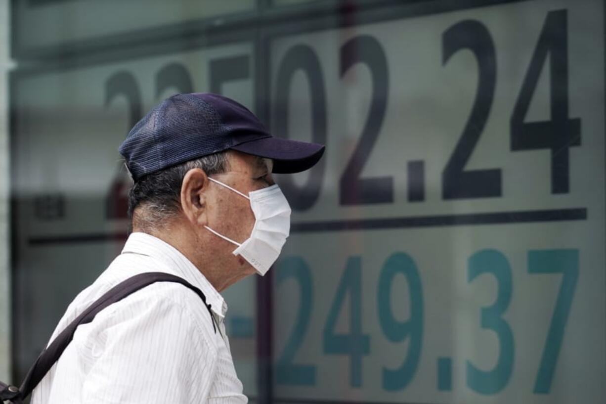 A man looks at an electronic stock board showing Japan&#039;s Nikkei 225 index at a securities firm in Tokyo Monday, July 27, 2020. Asian stock markets were mixed Monday amid U.S.-China tension and concern a recovery from the coronavirus pandemic might be weakening.