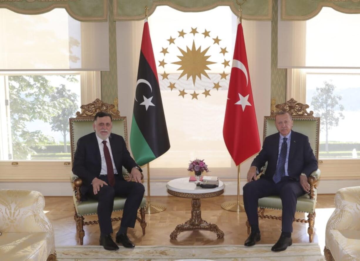 FILE - In this Saturday, July 25, 2020 file photo, Turkey&#039;s President Recep Tayyip Erdogan, right, and Fayez Sarraj, the head of Libya&#039;s internationally-recognized government, pose for photographs prior to their talks in Istanbul. Turkey is secretly expanding its footprint in conflict-ridden Libya, fueling the country&#039;s civil war and deepening fault lines with Mediterranean neighbors and between international allies. Turkey seems to be after lucrative construction and port contracts, according to Libyan officials.