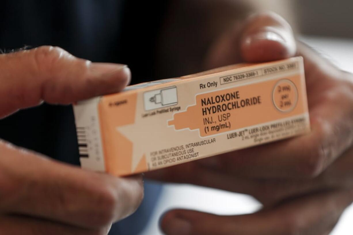 FILE - In this Wednesday, Sept. 11, 2019 file photo, a fire medic holds a box containing naloxone hydrochloride which is carried in all their department&#039;s emergency response vehicles, in Akron, Ohio. Doctors who prescribe opioid painkillers should tell their patients about a potentially life-saving medication that can reverse drug overdoses, according to new federal guidelines issued Thursday, July 23, 2020.