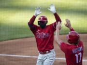 Philadelphia Phillies&#039; Didi Gregorius celebrates without touching, while wearing a mask, his three-run homer with Rhys Hoskins during the first inning of an exhibition baseball game against the Washington Nationals at Nationals Park, Saturday, July 18, 2020, in Washington.