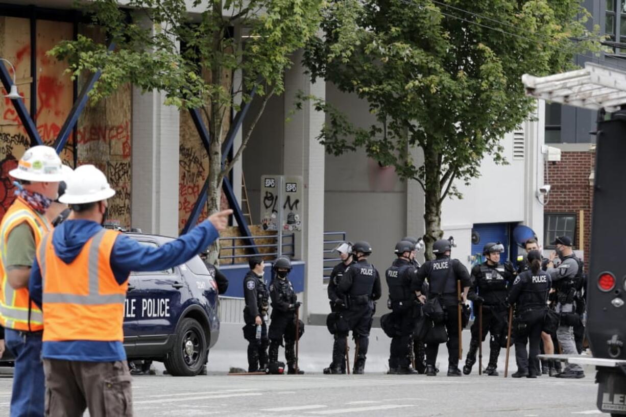 Police officers gather in front of a Seattle police precinct being cleaned and opened Wednesday, July 1, 2020, in Seattle, where streets had been blocked off in an area demonstrators had occupied for weeks. Seattle police showed up in force earlier in the day at the &quot;occupied&quot; protest zone, tore down demonstrators&#039; tents and used bicycles to herd the protesters after the mayor ordered the area cleared following two fatal shootings in less than two weeks. The &quot;Capitol Hill Occupied Protest&quot; zone was set up near downtown following the death of George Floyd while in police custody in Minneapolis.