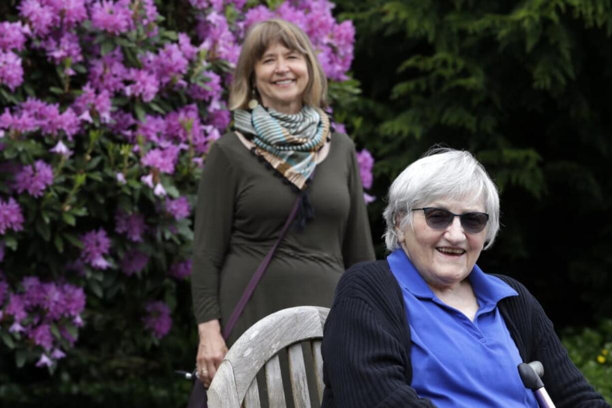 Jessie Cornwell, a resident of the Ida Culver House Ravenna, right, poses for a photo with the Rev. Jane Pauw, in Seattle on May 21, 2020. Cornwell tested positive for the coronavirus but never became ill, and may have been infectious when she shared a ride to Bible study with Pauw, who later got sick with COVID-19.