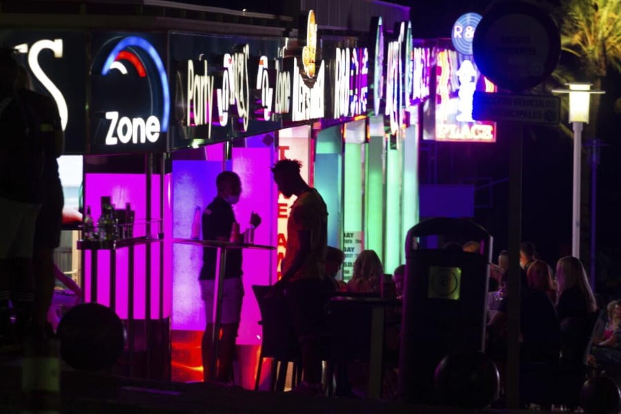 Tourists stand in a terrace at the resort of Magaluf on the Spanish Balearic island of Mallorca, Spain, Thursday, July 16, 2020. Authorities in Spain&#039;s Balearic Islands are pulling the plug on endless drunken nights to the beat of techno music by closing bars and nightclubs in beachfront areas popular with young and foreign visitors.