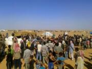 FILE - In this Aug. 4, 2016 file photo, people gather to take basic food stuffs and other aid from community leaders charged with distributing equitably the supplies to the 64,000-person refugee camp called Ruqban on the Jordan-Syria border. Over the last two days, members of the UN Security Council have been haggling over cross-border aid delivery to Syria, with Russia, a major ally of the Syria government, working to reduce the delivery of U.N. humanitarian aid to Syria&#039;s last rebel-held northwest down from two crossings to just one. A final vote is expected Friday, July 10, 2020 as western countries push on a new resolution to keep the two crossings open for six months, instead of a year.