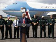 With Air Force One in the background, President Donald Trump speaks during a campaign event with Florida Sheriffs in Tampa, Fla., Friday, July 31, 2020.