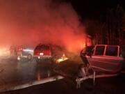 Firefighters battle an early morning blaze that destroyed a mobile home and three vehicles in the Van Ridge Mobile Home Park near Ridgefield.