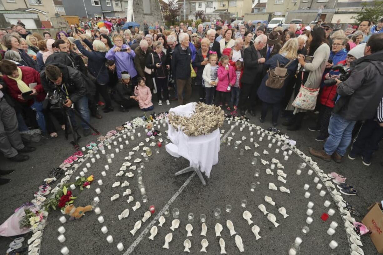 FILE - In this Aug. 26, 2018 file photo, People gather to protest at the site of the former Tuam home for unmarried mothers in County Galway, Ireland. The Vatican has indicated its support for a campaign to exhume the bodies of hundreds of babies who were buried on the grounds of a Catholic-run Irish home for unwed mothers to give them a proper Christian burial. The Vatican&#039;s ambassador to Ireland, Archbishop Jude Thaddeus Okolo, said in a July 15, 2020 letter to the amateur Irish historian behind the campaign that he shared the views of the archbishop of Tuam, Ireland, Michael Neary, who has said it was a &quot;priority&quot; for him to re-inter the bodies in consecrated ground.