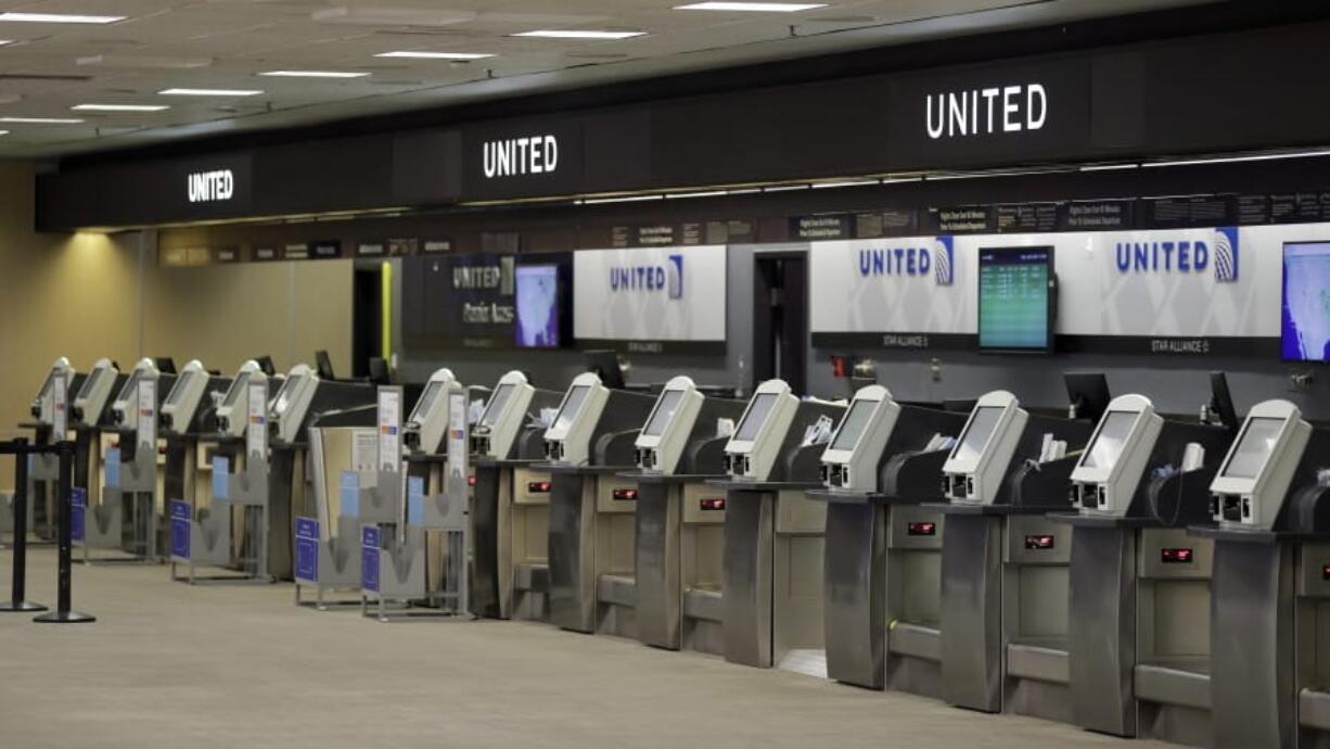 FILE - In this April 24, 2020 file photo, empty United Airlines ticket machines are shown at the Tampa International Airport in Tampa, Fla. United United Airlines will send layoff warnings to 36,000 employees - nearly half its U.S. staff - in the clearest signal yet of how deeply the virus outbreak is hurting the airline industry. United officials said Wednesday, July 8 that they still hope to limit the number of layoffs by offering early retirement, but they have to send notices this month to comply with a law requiring that workers get 60 days&#039; notice ahead of mass job cuts.