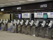 FILE - In this April 24, 2020 file photo, empty United Airlines ticket machines are shown at the Tampa International Airport in Tampa, Fla. United United Airlines will send layoff warnings to 36,000 employees - nearly half its U.S. staff - in the clearest signal yet of how deeply the virus outbreak is hurting the airline industry. United officials said Wednesday, July 8 that they still hope to limit the number of layoffs by offering early retirement, but they have to send notices this month to comply with a law requiring that workers get 60 days&#039; notice ahead of mass job cuts.