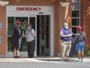 FILE - In this Tuesday, June 30, 2020, file photo, employees screen visitors for COVID-19 before they enter the building at Gritman Medical Center in Moscow, Idaho. A new spike in cases, however, has turned the mostly rural state into a COVID-19 hotspot.