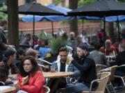 Members of the public are seen at a bar on Canal Street in Manchester&#039;s gay village, England, Saturday July 4, 2020. England is embarking on perhaps its biggest lockdown easing yet as pubs and restaurants have the right to reopen for the first time in more than three months. In addition to the reopening of much of the hospitality sector, couples can tie the knot once again, while many of those who have had enough of their lockdown hair can finally get a trim.