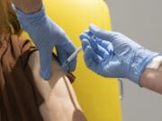 In this handout photo released by the University of Oxford a volunteer participates in the vaccine trial in Oxford, England on July 7, 2020. Scientists at Oxford University say their experimental coronavirus vaccine has been shown in an early trial to prompt a protective immune response in hundreds of people who got the shot. In research published Monday July 20, 2020 in the journal Lancet, scientists said that they found their experimental COVID-19 vaccine produced a dual immune response in people aged 18 to 55.