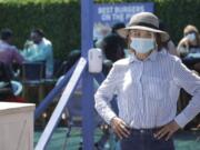 A hostess waits to sit customers on a restaurant at the pier Sunday, July 12, 2020, in Santa Monica, Calif., amid the coronavirus pandemic. A heat wave has brought crowds to California&#039;s beaches as the state grappled with a spike in coronavirus infections and hospitalizations.