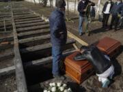 Peruvian migrant Jose Collantes grieves as he cries on the coffin that contains the remains of his wife Silvia Cano, who died due to COVID-19 complications, according to Collantes, at a Catholic cemetery in Santiago, Chile, Friday, July 3, 2020.