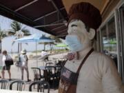 CORRECTS TO BROADWALK, INSTEAD OF BOARDWALK  A statue of a chef at Florio&#039;s of Little Italy restaurant wears a protective face mask on the Hollywood Beach Broadwalk during the new coronavirus pandemic, Thursday, July 2, 2020, in Hollywood, Fla. In hard-hit South Florida, beaches from Palm Beach to Key West will be shut down for the Fourth of July holiday weekend. Restaurants and businesses along the Boardwalk will remain open.