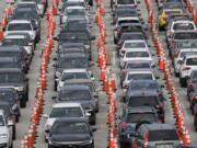 Lines of cars wait at a drive-through coronavirus testing site, Sunday, July 5, 2020, outside Hard Rock Stadium in Miami Gardens, Fla. Florida health officials say the state has reached a grim milestone: more than 200,000 people have tested positive for the novel coronavirus since the start of the outbreak.