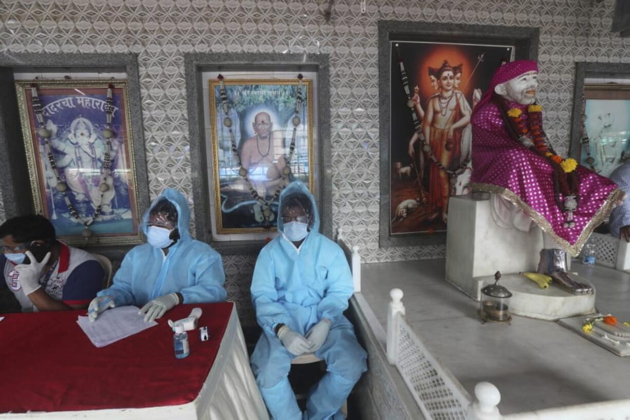 Health workers wait to screen people for COVID-19 symptoms at a temple in Mumbai, India, Saturday, July 18, 2020. India crossed 1 million coronavirus cases on Friday, third only to the United States and Brazil, prompting concerns about its readiness to confront an inevitable surge that could overwhelm hospitals and test the country&#039;s feeble health care system.