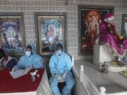 Health workers wait to screen people for COVID-19 symptoms at a temple in Mumbai, India, Saturday, July 18, 2020. India crossed 1 million coronavirus cases on Friday, third only to the United States and Brazil, prompting concerns about its readiness to confront an inevitable surge that could overwhelm hospitals and test the country&#039;s feeble health care system.