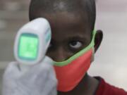 A health worker checks the body temperature of a boy at a medical camp to screen residents for COVID-19 symptoms in Mumbai, India, Friday, July 17, 2020. India crossed 1 million coronavirus cases on Friday, third only to the United States and Brazil, prompting concerns about its readiness to confront an inevitable surge that could overwhelm hospitals and test the country&#039;s feeble health care system.