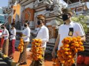 Airport officers wearing face masks line up as they hold flowers to welcome passengers at Bali airport, Indonesia on Friday, July 31, 2020. Indonesia&#039;s resort island of Bali reopened for domestic tourists after months of lockdown due to a new coronavirus.