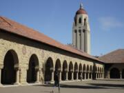 FILE- In this March 14, 2019, file photo, people walk on the Stanford University campus beneath Hoover Tower in Stanford, Calif. A week after revoking sweeping new restrictions on international students, federal immigration officials on Friday, July 24, 2020, announced that new foreign students will be barred from entering the United States if they plan to take their classes entirely online this fall.