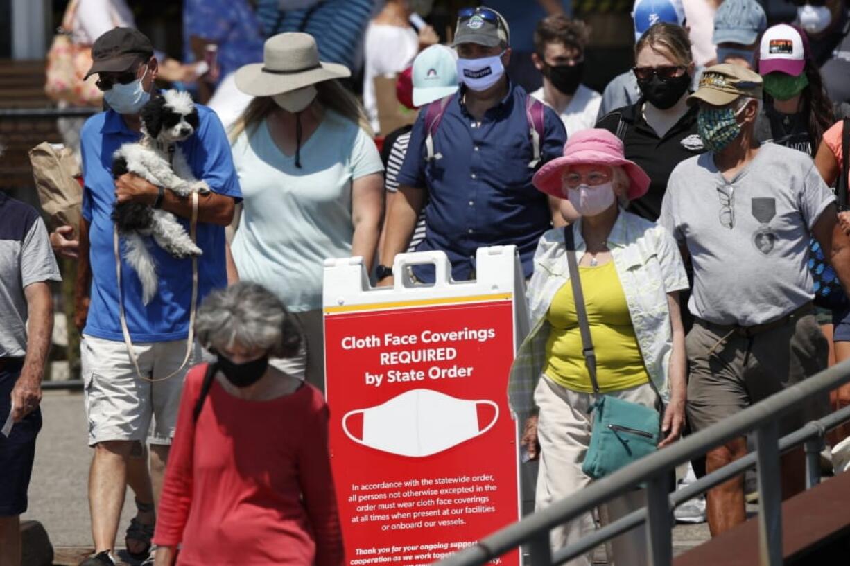 Passengers board a Casco Bay Lines ferry bound for Peaks Island on Thursday in Portland, Maine. State officials reported more cases of COVID-19. (Robert F.