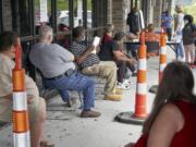 Job seekers exercise social distancing as they wait to be called into the Heartland Workforce Solutions office in Omaha, Neb., Wednesday, July 15, 2020. Nebraska reinstated job search requirements this week for most people claiming jobless benefits. Those unemployment insurance requirements were suspended in mid-March to help employees who had lost their jobs due to the coronavirus.