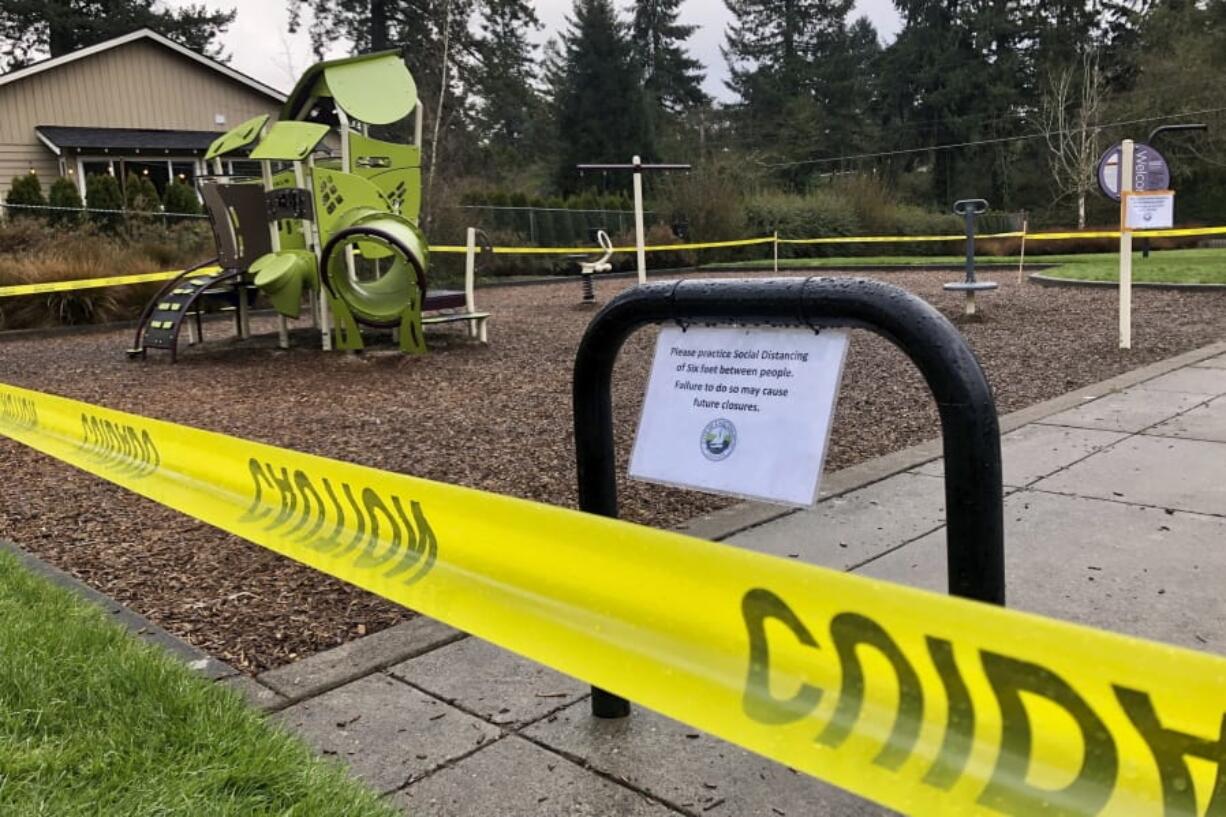 FILE - In this March 24, 2020, file photo, police caution tape surrounds a playground in Lake Oswego, Ore., during the coronavirus outbreak. Oregon health officials reported its second-highest tally of confirmed cases of COVID-19 and five additional deaths on Friday, June 26, 2020, the same day that authorities released new modeling that shows increased transmission of the coronavirus since the state began reopening in mid-May.