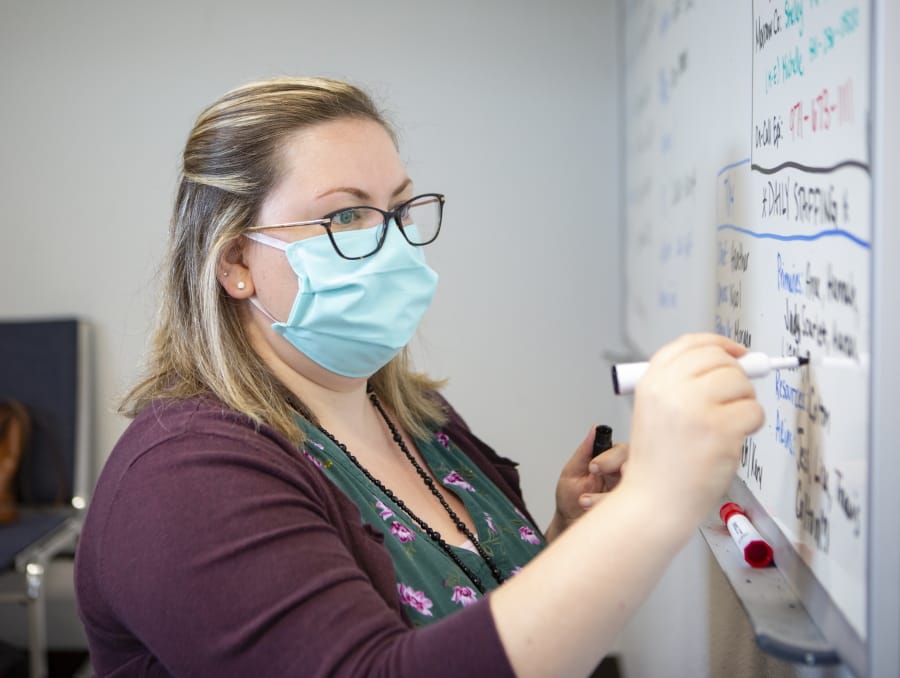 Heather Griggs, a registered nurse and operations chief of the Umatilla County Public Health Department contact tracing center in Pendleton, Ore., updates a list of job assignments on Tuesday, July 14, 2020. In tiny Umatilla County in northeastern Oregon, contact tracers work out of a converted jail to try to stem the spread of COVID-19 as new cases surge in the rural West and elsewhere.