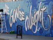 FILE - In this July 10, 2020, file photo, Artist Jimmy Baptiste works on a mural in Ottawa. 2020 is barely halfway over. That hasn&#039;t stopped many people from declaring the year canceled and wishing it would end.