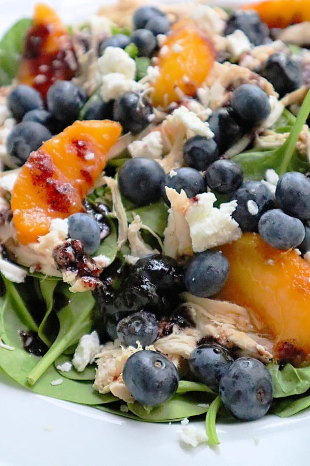 A handful of blueberries add antioxidants to a summer salad tossed with shredded chicken and peaches in a blueberry jam vinaigrette.