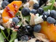 A handful of blueberries add antioxidants to a summer salad tossed with shredded chicken and peaches in a blueberry jam vinaigrette.