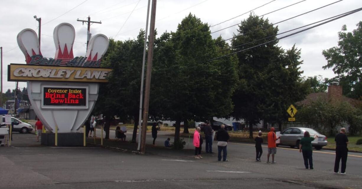 Supporters hold up signs and wave at passing cars in front of Crosley Lanes on Saturday, Aug. 8, 2020, during a Rally for the Alley to help get bowling centers reopened in the state.