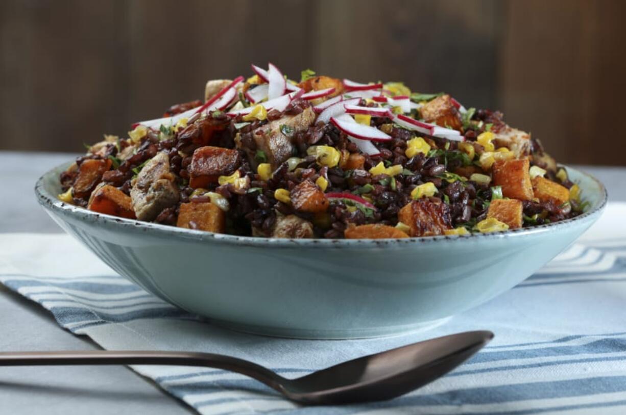 A chilled salad of black and brown rice contrasts beautifully with yellow corn, red radishes, orange squash and bright green herbs.