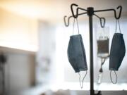 Face masks hang from an IV pole at a hospital in Portland on Aug. 8.