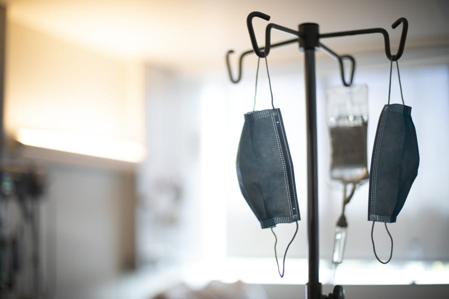 Face masks hang from an IV pole at a hospital in Portland on Aug. 8.