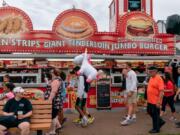 People walk past a food stand at the Iowa State Fair on August 11, 2019 in Des Moines, Iowa.