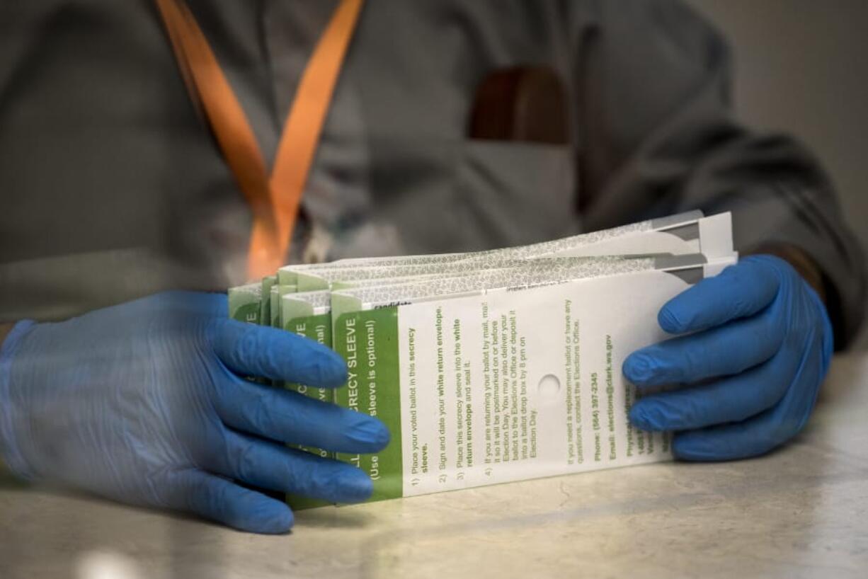 Election workers use protective gloves to handle ballots at the Clark County Elections Office while processing the Aug. 4 primary election.