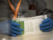 Election workers use protective gloves to handle ballots at the Clark County Elections Office while processing the Aug. 4 primary election.