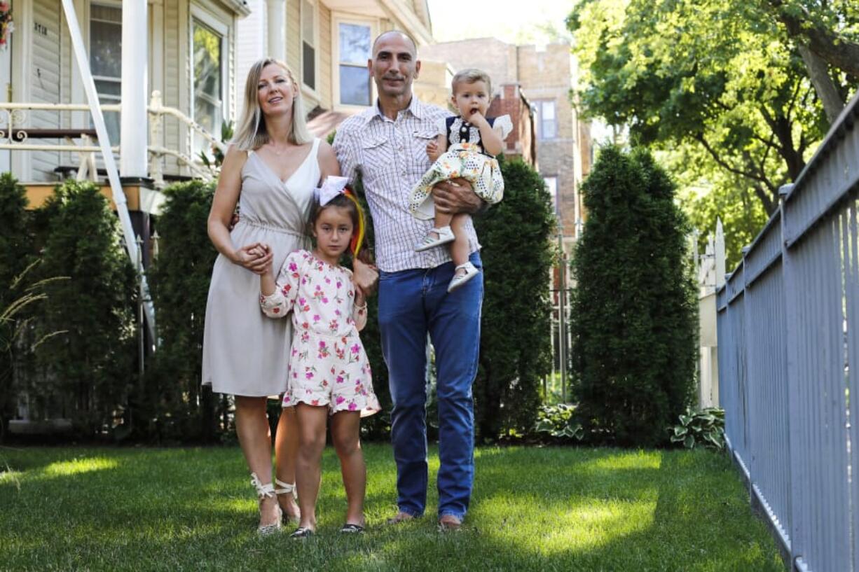 Vahap Sarac, right, holding daughter Ella, 1, his wife Rita Sarac and daughter  Ada, 6, in Chicago&#039;s Albany Park neighborhood on August 12, 2020. Sarac who worked as a banquet captain at the Palmer House until he was laid off in March. His health insurance, which covers him, his wife and two kids, is set to expire in October, at which point he&#039;s not sure what he&#039;ll do. He and his wife have even discussed sending the kids to live with their grandparents in Estonia, where there are fewer COVID cases and universal health care. (Jose M.