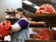 Rosa Romero dabs paint off of a Down to Earth mask at Zagone Studios on Thurs., Aug. 20, 2020 in Melrose Park. During a typical year they would produce 125,000 masks but not so this year because of coronavirus.  They have been making masks for 40 years.