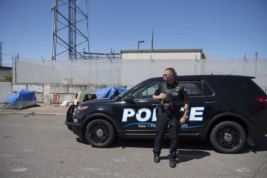 Officer Tyler Chavers stops to check on a homeless encampment near Share House in downtown Vancouver in July 2020.