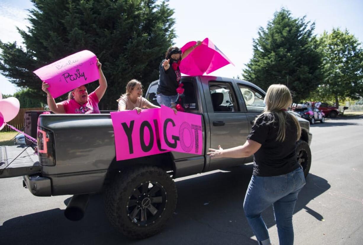 Sherry Cianni, from left, Madilynn Reagan and Gina Salt drive by Heather James&#039; home in Felida during a parade of support Saturday. James was diagnosed with breast cancer in April so her friends and co-workers decided to organize the socially-distanced parade. Cianni is also battling breast cancer, so she and James have been able to support each other.