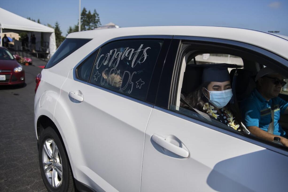 Henrietta Lacks Health and Bioscience High School graduate Cassandra Micah, 18, joins loved ones in her car after walking across the stage to celebrate her accomplishments at McKenzie Stadium on Wednesday morning. Evergreen Public Schools students took part in a drive-thru graduation ceremony, celebrating a year interrupted by the coronavirus pandemic.