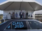 Ilya Panasevich, 18, graduate of Henrietta Lacks Health and Bioscience High School, takes center stage as he pauses to have his photograph taken during a drive-thru graduation ceremony for the class of 2020 at McKenzie Stadium on Wednesday morning. Panasevich was one of 147 graduates from HeLa High School this year, and one of about 1,900 in the Evergreen Public Schools district.