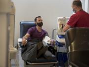 Michael Chubbuck of Portland, left, donates convalescent plasma, which is collected from COVID-19 survivors that contain antibodies, while chatting with apheresis tech Brendan Turnbull at the Red Cross Portland donation center Wednesday morning. Local blood banks are encouraging residents in the Portland-Vancouver metro area who have recovered from COVID-19 to visit a branch and donate plasma to aid researchers in finding a cure.