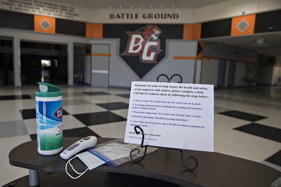 A station is set up to screen visitors to Battle Ground High School for symptoms of COVID-19, as seen on Tuesday morning. Districts like Battle Ground are eligible for coronavirus relief funds to help cover the cost of responding to the pandemic, including the purchase of personal protective equipment and technology.