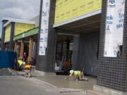 Construction workers bring a new Grocery Outlet store to life at Evergreen Plaza on Wednesday. The location is a former Salvation Army thrift store.