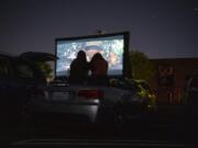 Alexa Malone, left, and Maryam Ali, right, both 17 and of Camas, sit atop their friendis convertible as they watch &quot;Raiders of the Lost Ark&quot; during the Pop Up Cinema in the Vancouver Mall parking lot on Friday.